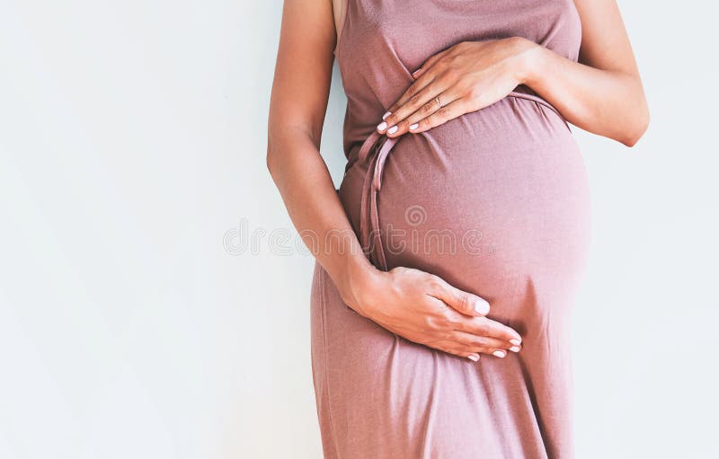 La femme enceinte tient des mains sur le ventre Plan rapproché photos stock La femme enceinte tient des mains sur le ventre Plan rapproché photos stock