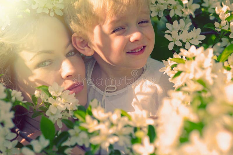 La femme et l'enfant heureux pendant le ressort de floraison font du jardinage photo stock La femme et l'enfant heureux pendant le ressort de floraison font du jardinage photo stock