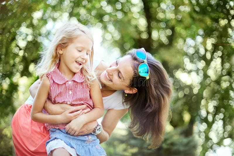 La femme et l'enfant heureux pendant le ressort de floraison font du jardinage Concept de vacances de jour de mères photo libre de droits La femme et l'enfant heureux pendant le ressort de floraison font du jardinage Concept de vacances de jour de mères photo libre de droits