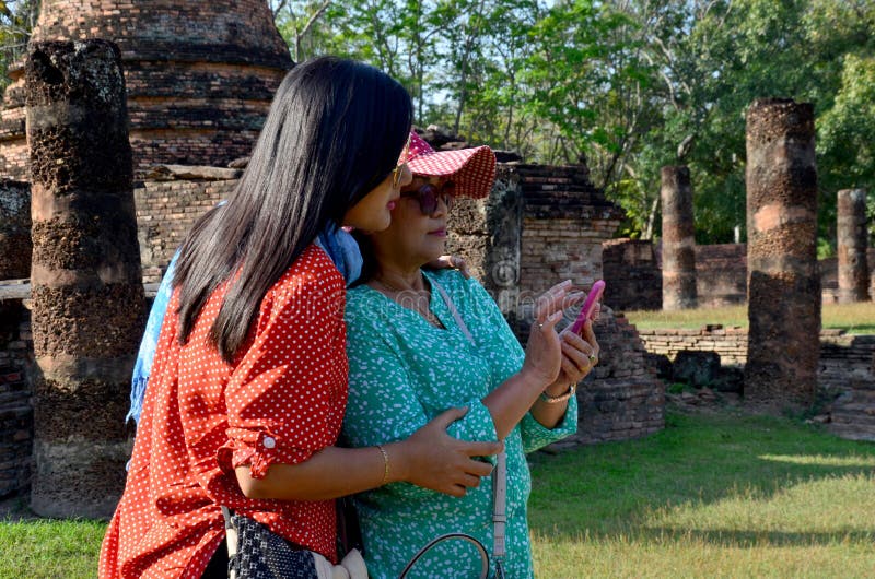 La femme et les dames âgées thaïlandaises jouent le mobile dans le bâtiment antique photo stock La femme et les dames âgées thaïlandaises jouent le mobile dans le bâtiment antique photo stock