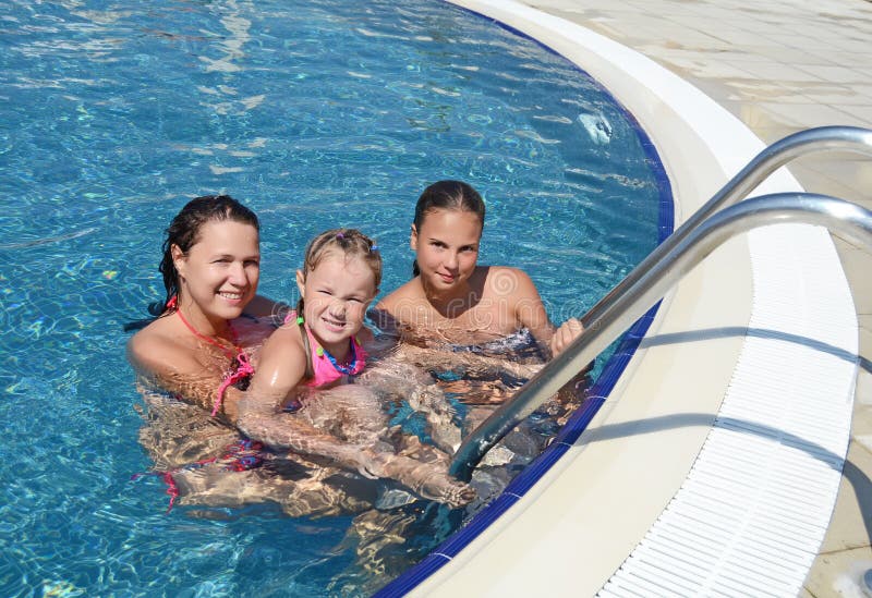 La femme et sa fille ont un amusement dans la piscine extérieure photographie stock La femme et sa fille ont un amusement dans la piscine extérieure photographie stock