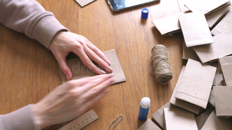 La femme fait des sacs en papier d'a à partir du papier d'emballage pour le calendrier d'avènement Remet le plan rapproché Plie l clips vidéos