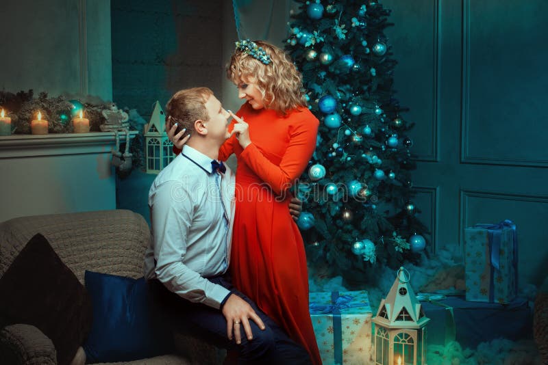 La femme frotte l'homme de flirt de nez pendant la nuit de Noël image stock La femme frotte l'homme de flirt de nez pendant la nuit de Noël image stock