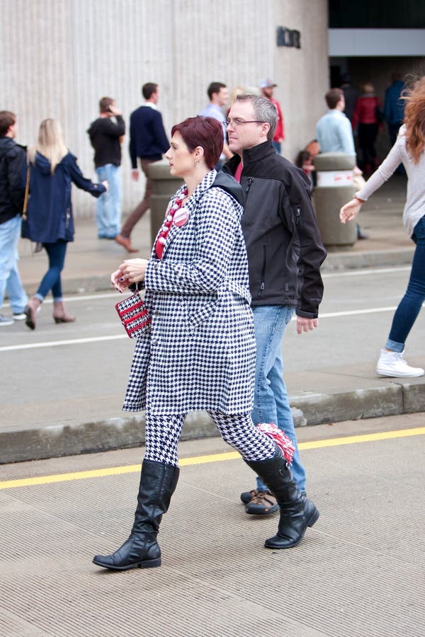La femme habillée dans tout le pied-de-poule dispose à observer le jeu de l'Alabama photo stock La femme habillée dans tout le pied-de-poule dispose à observer le jeu de l'Alabama photo stock