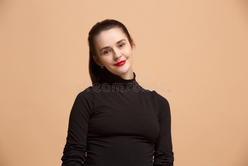 La femme heureuse d'affaires se tenant et souriant sur le fond en pastel images libres de droits La femme heureuse d'affaires se tenant et souriant sur le fond en pastel images libres de droits