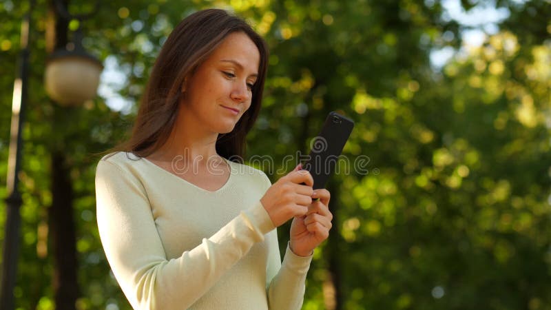 La femme heureuse ont plaisir à passer en revue dans le smartphone