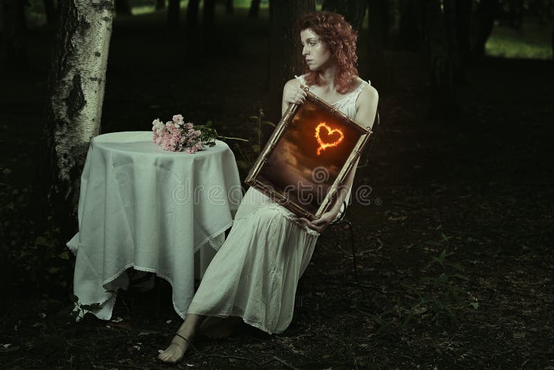 La femme lui montre le coeur brûlant photo stock La femme lui montre le coeur brûlant photo stock