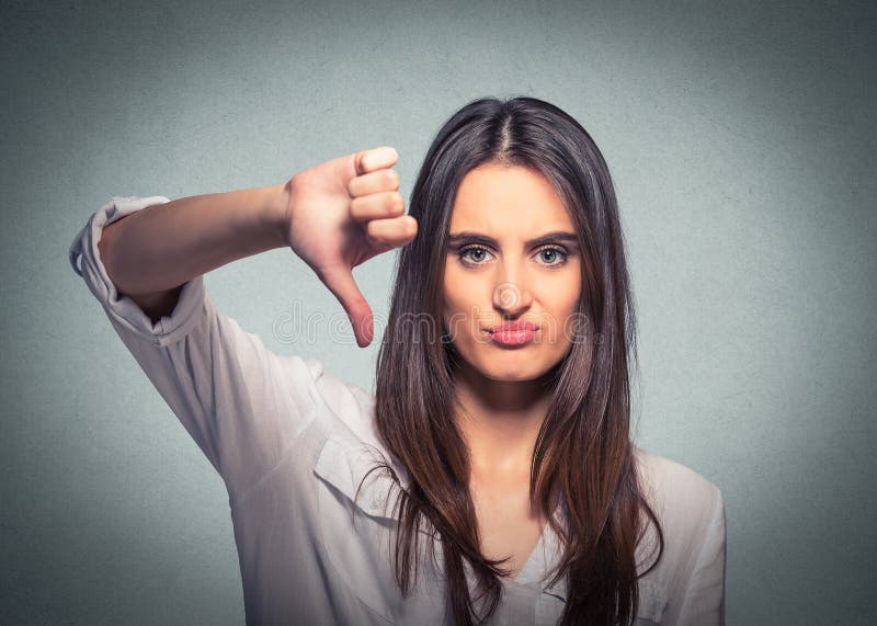 La femme malheureuse donnant le pouce font des gestes vers le bas le regard avec l'expression négative photo stock La femme malheureuse donnant le pouce font des gestes vers le bas le regard avec l'expression négative photo stock