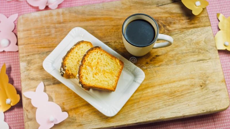 La femme met une tasse de café sur la table où il y a un gâteau au chocolat. sur le fond sont purges de pâques faites clips vidéos