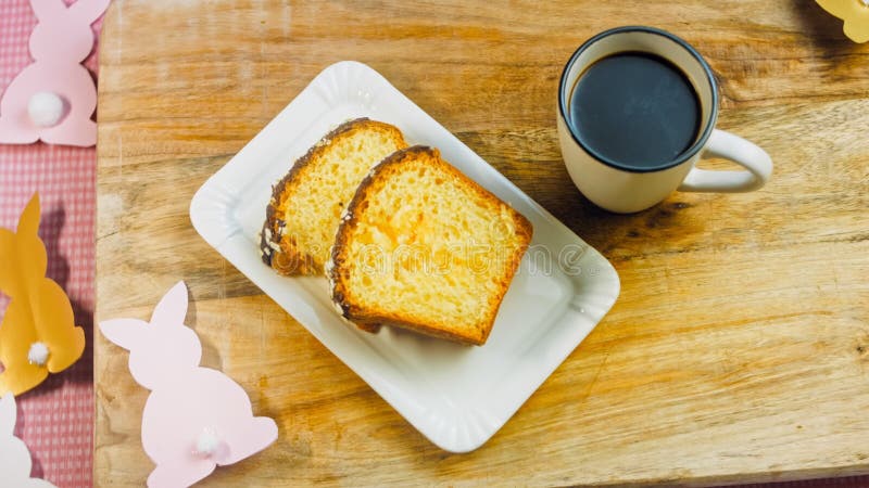 La femme met une tasse de café sur la table où il y a un gâteau au chocolat. sur le fond sont purges de pâques faites banque de vidéos
