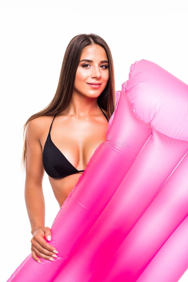 La femme mignonne heureuse de brune se trouve sur le matelas gonflable jaune dans le bikini d'isolement au-dessus du fond blanc É photos libres de droits La femme mignonne heureuse de brune se trouve sur le matelas gonflable jaune dans le bikini d'isolement au-dessus du fond blanc É photos libres de droits