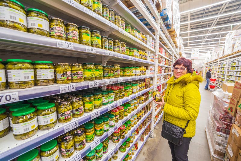 La femme mûre choisit les légumes en boîte dans un supermarché photo libre de droits La femme mûre choisit les légumes en boîte dans un supermarché photo libre de droits