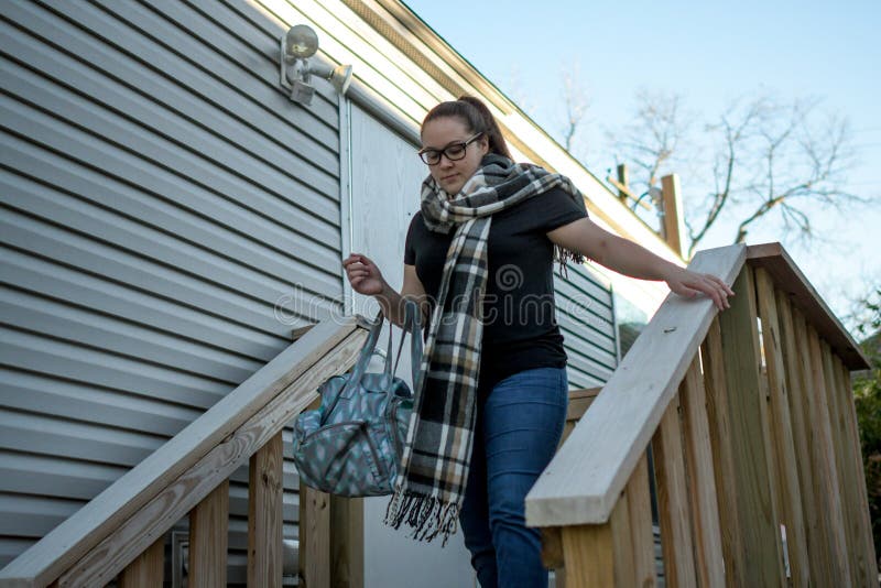 La femme part à la maison avec le sac drapé au-dessus de son bras photo libre de droits La femme part à la maison avec le sac drapé au-dessus de son bras photo libre de droits