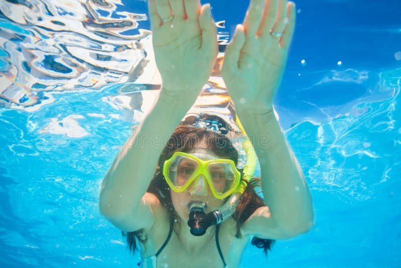 La femme porte le masque naviguant au schnorchel nageant sous l'eau photo stock La femme porte le masque naviguant au schnorchel nageant sous l'eau photo stock