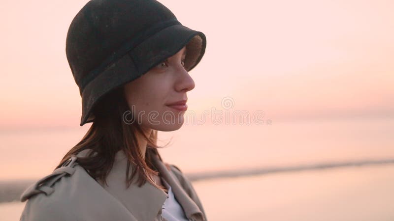La femme pose pour la caméra et jouit d'une vue de la nature sur la plage pour égaliser le coucher du soleil. banque de vidéos