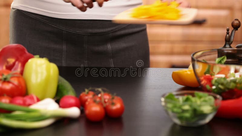 La femme remet couper les tranches jaunes de poivre pour une salade banque de vidéos