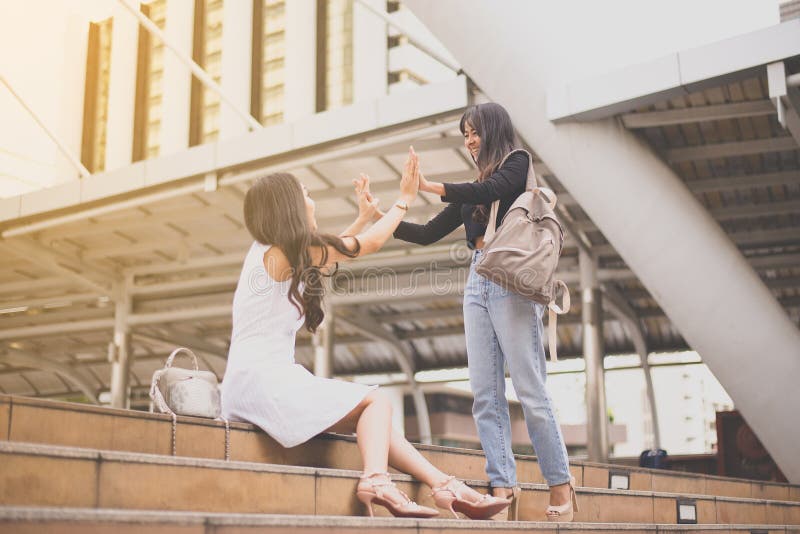 La femme remet la réunion, salutation heureuse de l'ami deux dans le CIT photo libre de droits La femme remet la réunion, salutation heureuse de l'ami deux dans le CIT photo libre de droits