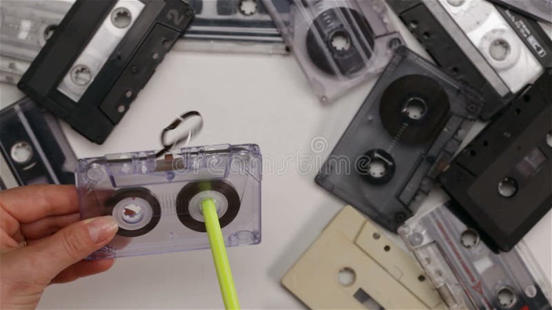 La femme renvoie à bobine la bande dans la cassette sonore utilisant un stylo - vue supérieure, plan rapproché banque de vidéos