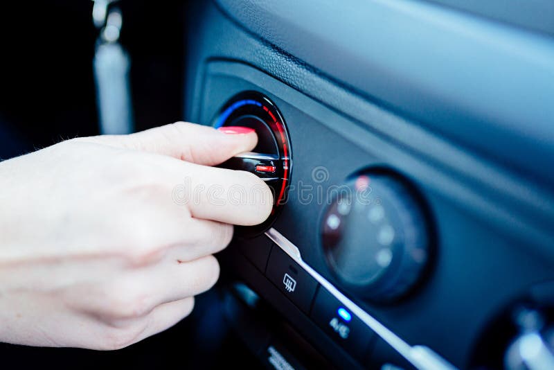 La femme règle le chauffage dans sa voiture photos stock La femme règle le chauffage dans sa voiture photos stock