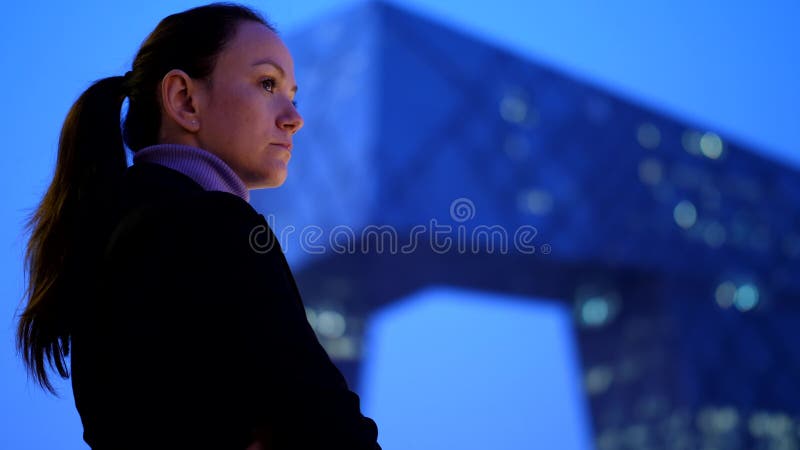 La femme réfléchie apprécient le paysage urbain et le gratte-ciel modernes la nuit