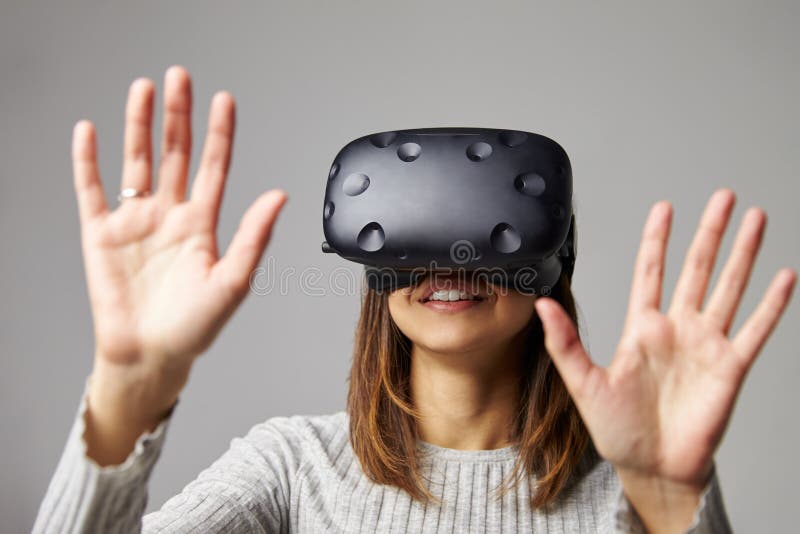 La femme s'assied sur le casque de réalité de Sofa At Home Wearing Virtual photo stock