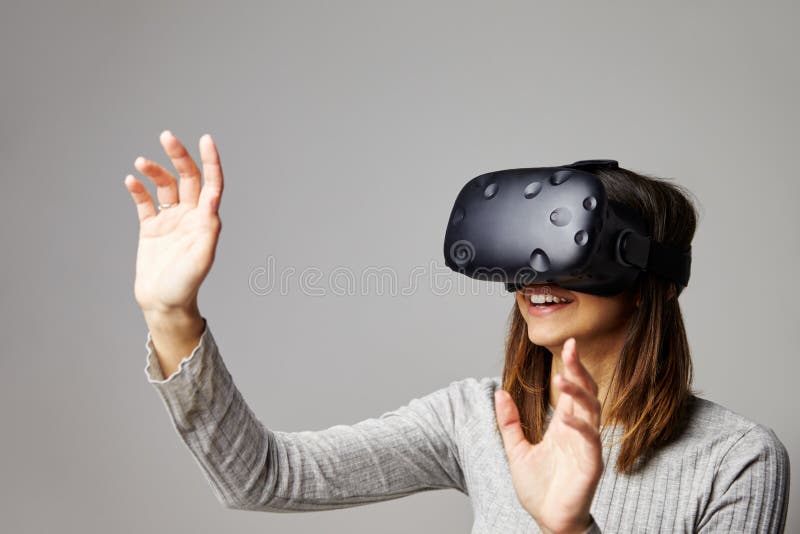 La femme s'assied sur le casque de réalité de Sofa At Home Wearing Virtual photo libre de droits