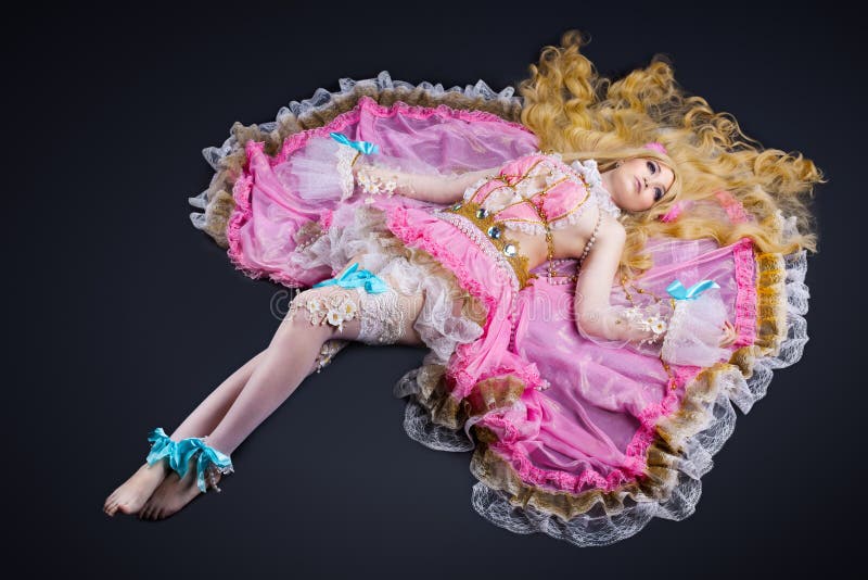 La femme s'étendent dans le costume cosplay de poupée de joint à rotule image stock La femme s'étendent dans le costume cosplay de poupée de joint à rotule image stock