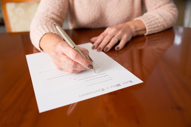 La femme supérieure signant pour la dernière fois et testament à la maison photographie stock La femme supérieure signant pour la dernière fois et testament à la maison photographie stock