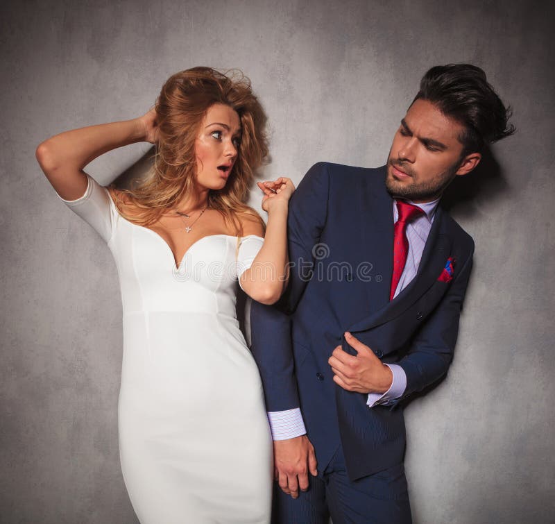 La femme élégante stupéfaite par jeunes regarde son homme photo stock La femme élégante stupéfaite par jeunes regarde son homme photo stock