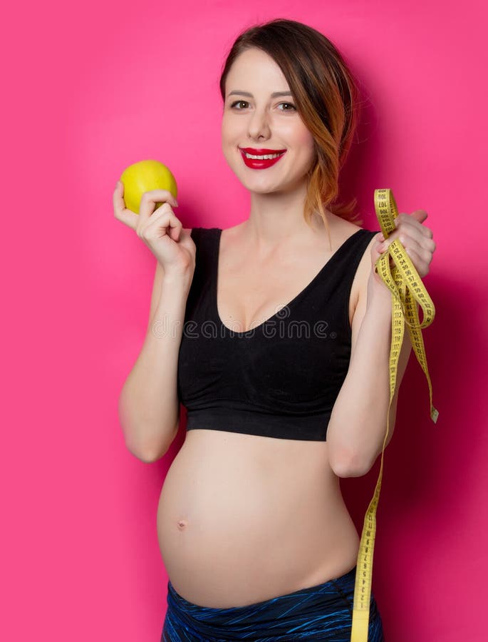 La femmina nella forma fisica copre con la misura e la mela di nastro immagini stock libere da diritti La femmina nella forma fisica copre con la misura e la mela di nastro immagini stock libere da diritti