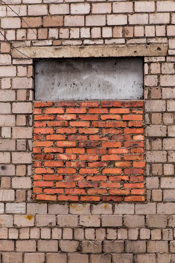 La fenêtre bricked La fenêtre est brique étendue Mur de briques gris avec une fenêtre étendue avec la brique rouge La fenêtre es photo stock La fenêtre bricked La fenêtre est brique étendue Mur de briques gris avec une fenêtre étendue avec la brique rouge La fenêtre es photo stock