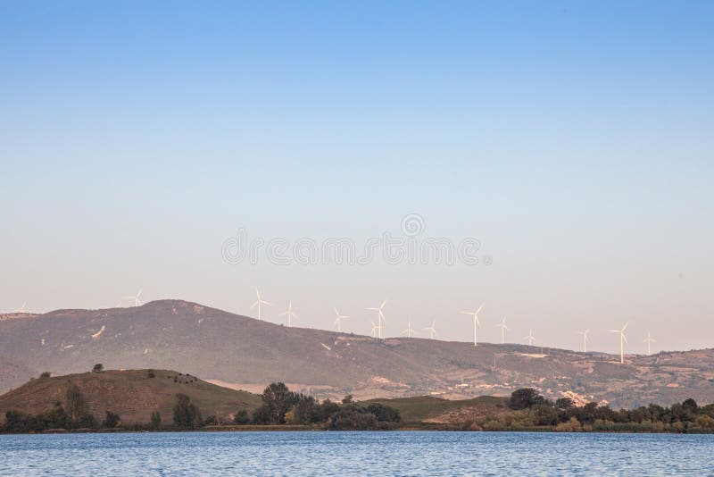 La ferme de vent roumaine avec des turbines et des moulins à vent de vent faisant face au Danube, dans le fer déclenche la vallée image libre de droits La ferme de vent roumaine avec des turbines et des moulins à vent de vent faisant face au Danube, dans le fer déclenche la vallée image libre de droits