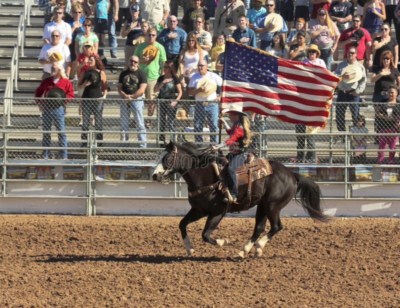 Tucson, Arizona - February 15: The La Fiesta De Los Vaqueros Rodeo on February 15, 2014, in Tucson, Arizona. A horsewomen displays the American Flag at the 89th Annual 2014 Tucson Rodeo. Tucson, Arizona - February 15: The La Fiesta De Los Vaqueros Rodeo on February 15, 2014, in Tucson, Arizona. A horsewomen displays the American Flag at the 89th Annual 2014 Tucson Rodeo.