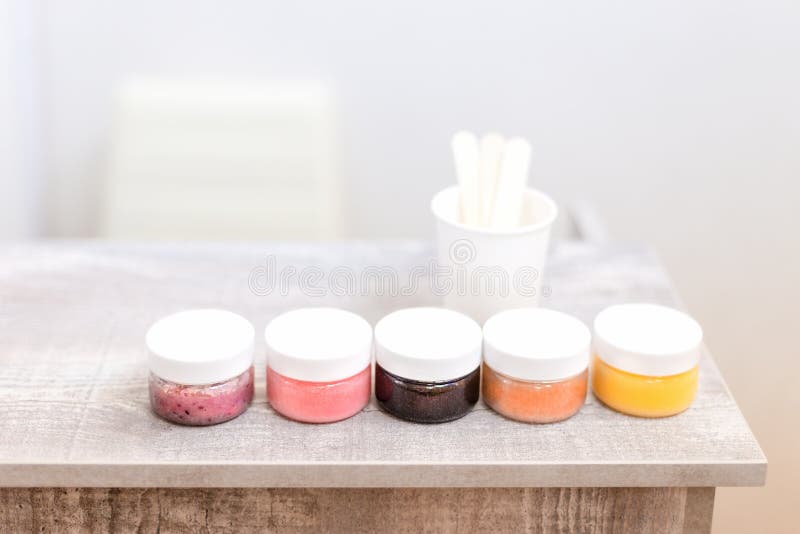 La fila dei vasi con sfrega su una tavola di ricezione del salone di bellezza fotografia stock libera da diritti La fila dei vasi con sfrega su una tavola di ricezione del salone di bellezza fotografia stock libera da diritti