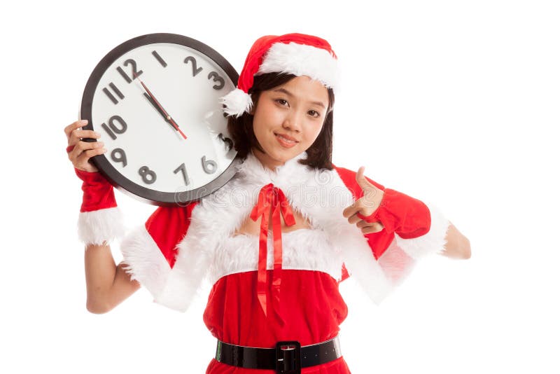 La fille asiatique de Santa Claus de Noël manie maladroitement avec l'horloge au midnig