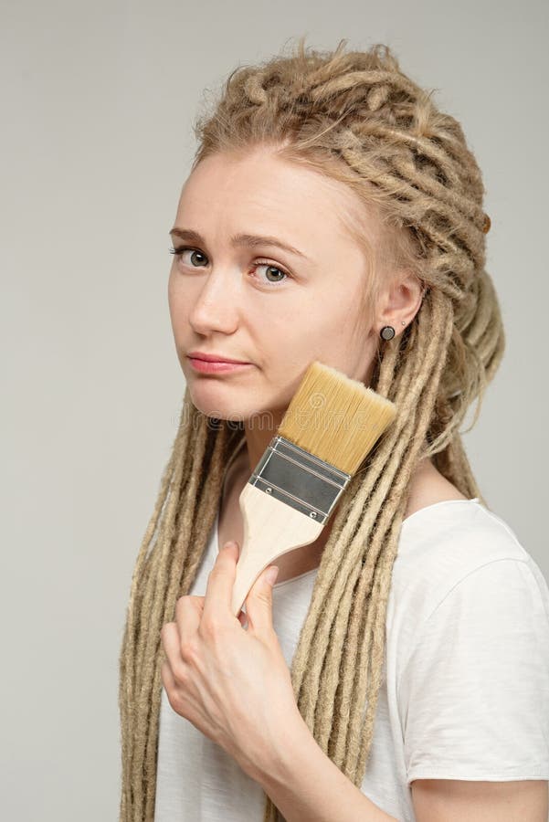 La Fille Avec De Longs Dreadlocks Tient La Brosse Dans Ses Mains