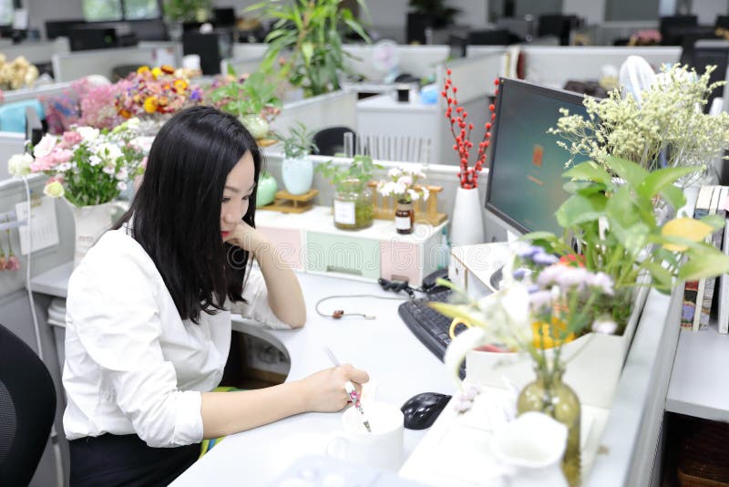 La fille chinoise de femme de dame de bureau de l'Asie s'asseyent sur la chaise prennent des notes sur le lieu de travail de cost photo stock La fille chinoise de femme de dame de bureau de l'Asie s'asseyent sur la chaise prennent des notes sur le lieu de travail de cost photo stock