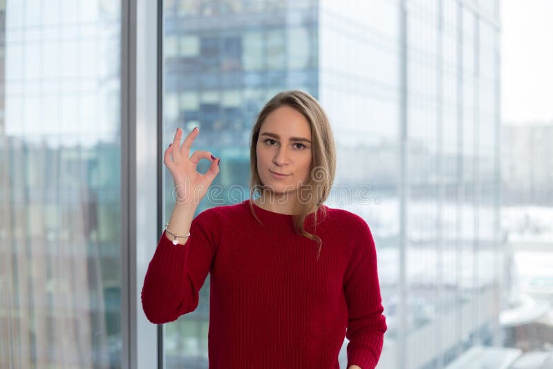 La fille d'affaires à la fenêtre montre un doigt qui tout est bien approbation d'un associé négociation d'affaires photo libre de droits La fille d'affaires à la fenêtre montre un doigt qui tout est bien approbation d'un associé négociation d'affaires photo libre de droits