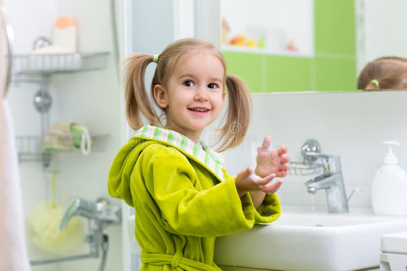 La fille d'enfant montre les mains savonneuses photographie stock libre de droits La fille d'enfant montre les mains savonneuses photographie stock libre de droits