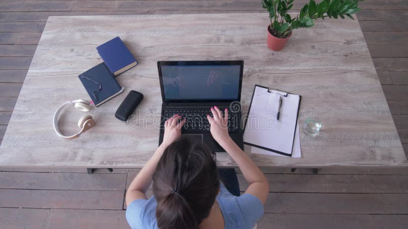 La fille d'indépendant trace un graphique en presse-papiers et texte de dactylographie sur le clavier d'ordinateur portable se re