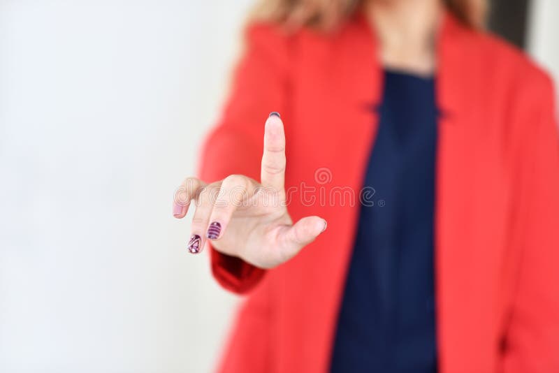 La fille dans la veste rouge pousse le bouton virtuel de doigt image stock La fille dans la veste rouge pousse le bouton virtuel de doigt image stock