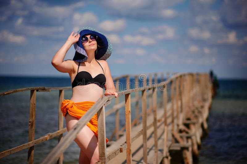 La fille dans un chapeau bleu va le long du pilier photos libres de droits La fille dans un chapeau bleu va le long du pilier photos libres de droits