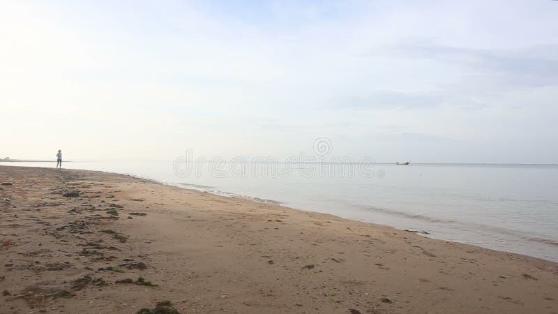 la fille de brune court au delà sur la plage contre le bateau à l'aube