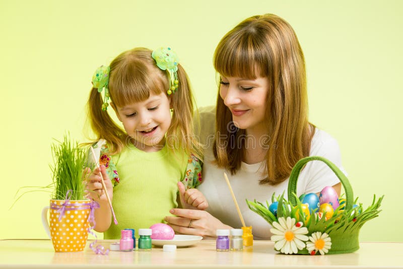 La fille de mère et d'enfant peignent des oeufs préparant aux vacances de Pâques image libre de droits La fille de mère et d'enfant peignent des oeufs préparant aux vacances de Pâques image libre de droits