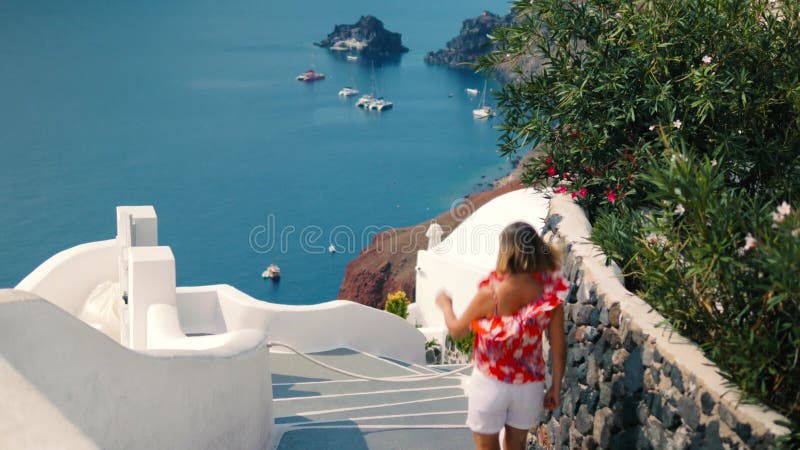 La fille descend un escalier dans le santorin. La vie de luxe sur le santorin Grèce.