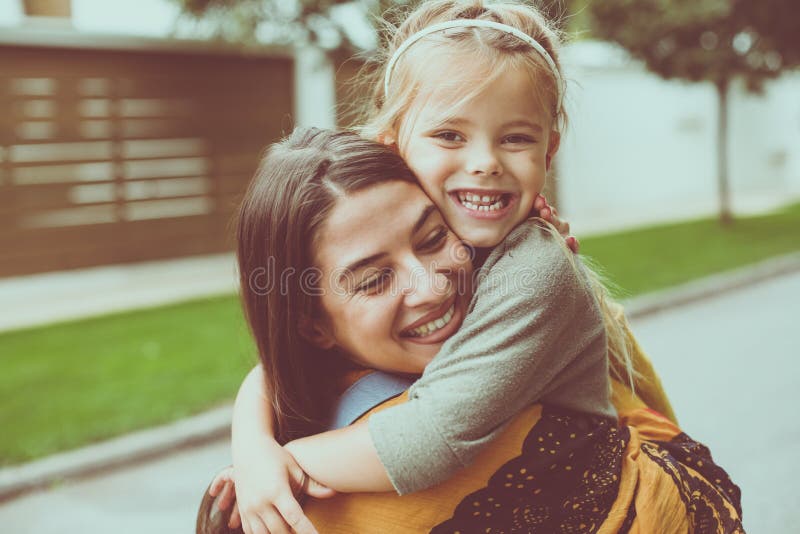 La fille donne à étreinte une maman Petite fille heureuse image stock