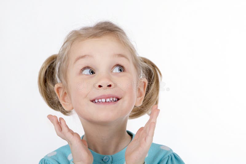 La fille drôle badine les mains de sourire à son visage images libres de droits La fille drôle badine les mains de sourire à son visage images libres de droits