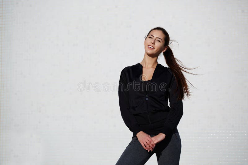 La fille en bonne santé sportive s'est habillée dans les vêtements de sport posant dehors photos stock La fille en bonne santé sportive s'est habillée dans les vêtements de sport posant dehors photos stock