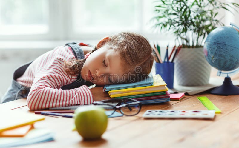 La fille fatigu?e d'enfant est tomb?e endormi quand elle a fait ses devoirs ? la maison image libre de droits La fille fatigu?e d'enfant est tomb?e endormi quand elle a fait ses devoirs ? la maison image libre de droits