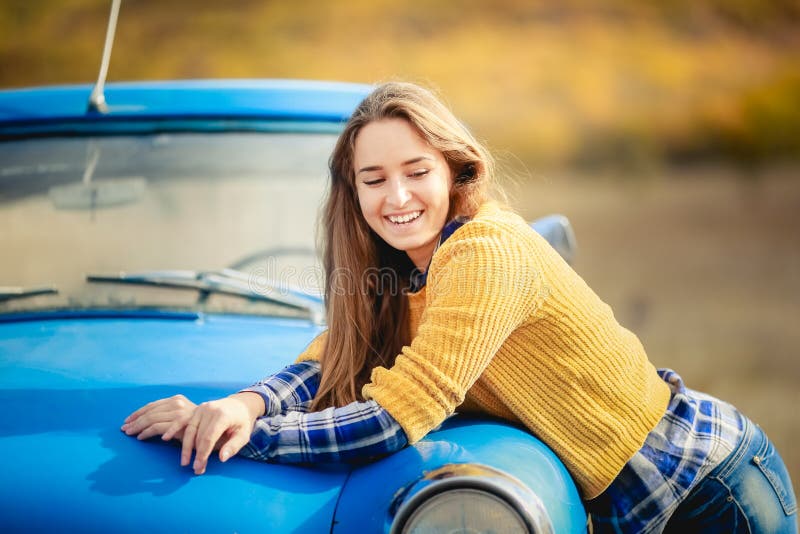 La fille gaie de sourire avec de longs cheveux, portant dans le chapeau noir et le chandail jaune, et apprécie la liberté, se ten photos libres de droits La fille gaie de sourire avec de longs cheveux, portant dans le chapeau noir et le chandail jaune, et apprécie la liberté, se ten photos libres de droits